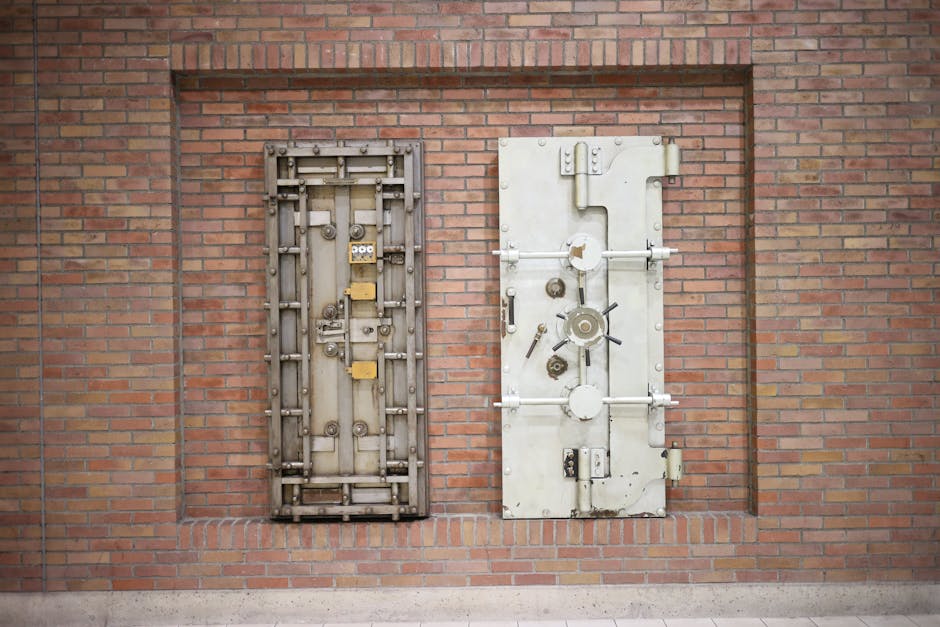 Two steel security vault doors attached to a vintage brick wall, showcasing industrial strength.