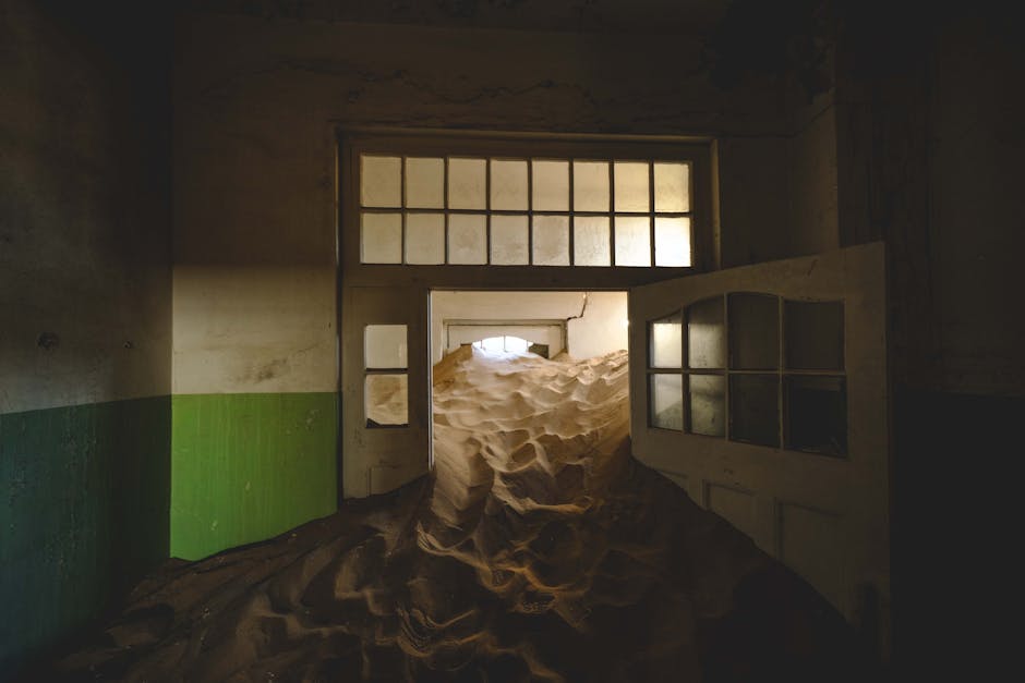 Eerie sand-swept room in Kolmanskop, showcasing the haunting beauty of an abandoned ghost town.